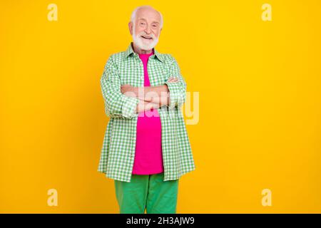 Portrait of attractive cheerful grey-haired man folded arms wearing checked shirt isolated over vibrant yellow color background Stock Photo