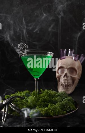 Halloween green cocktails with skulls, spiders and smoke on black background. Horror funny food. Stock Photo