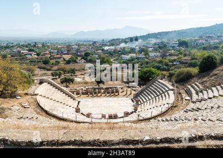 View over reconstructed theatre at Metropolis ancient site in Izmir province of Turkey, with Yenikoy village in the background. In addition to theatri Stock Photo