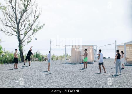SEVAN, ARMENIA - Sep 03, 2021: A group of young people playing volleyball on the beach at Lake Sevan, Armenia Stock Photo