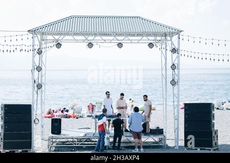 SEVAN, ARMENIA - Sep 03, 2021: A group of young people enjoying the beach party on the shore of Lake Sevan, Armenia Stock Photo