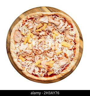top view of frozen pizza with chicken slices and pineapple pieces on cutting board cutout on white background Stock Photo