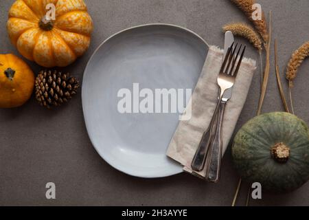 Overhead autumn thanksgiving dinner place setting with pumpkins cutlery and an empty plate Stock Photo