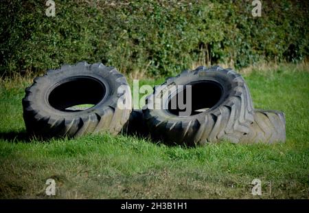 Four used tractor tyres left in a field Stock Photo