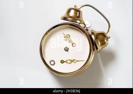 Clock change problem, vintage alarm clock with loose hands has lost orientation and digits at the changeover from daylight saving time to standard tim Stock Photo