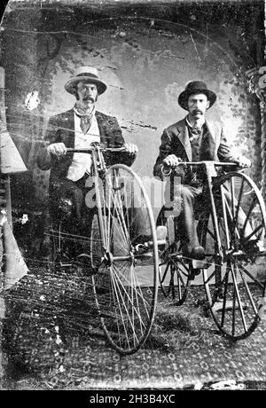 Vintage black and white tintype of two men on high wheel bicycles Stock Photo