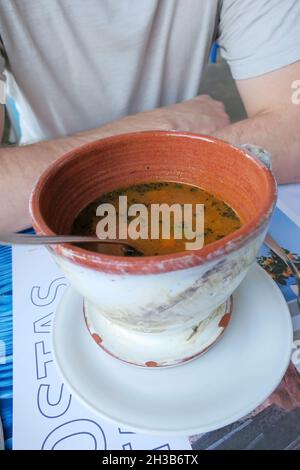 Ayia Napa, Cyprus - 14 October, 2021: Lunch fish soup in a craft pot at one of the popular Greek taverns Stock Photo