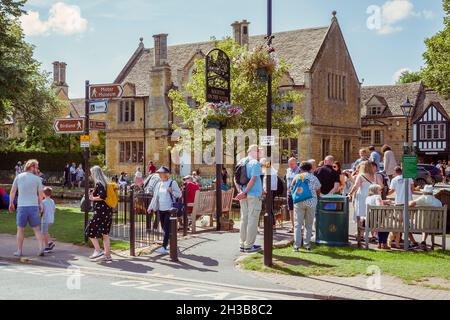 Crowds of visitors enjoying a sunny day in Bourton On The Water, a picturesque village in The Cotswolds, United Kingdom. Stock Photo