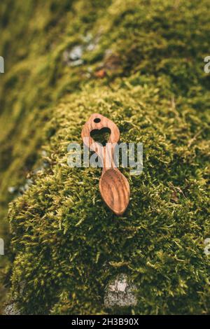 Wooden love spoons from Wales on mossy stone background. Traditional welsh wooden spoons. Stock Photo