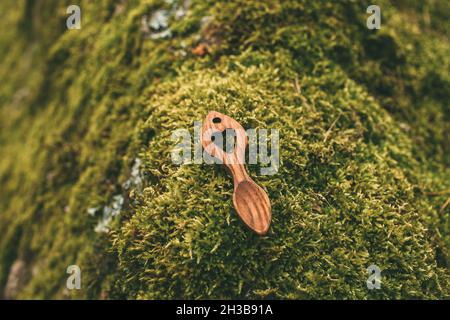Wooden love spoons from Wales on mossy stone background. Traditional welsh wooden spoons. Stock Photo