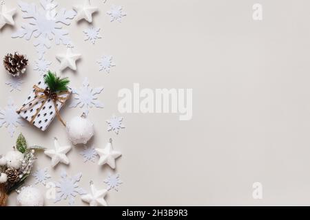 New Year's composition. Christmas gift pine cones fir branches snowflakes and stars on a light gray background. Top view flat lay copy space. Stock Photo