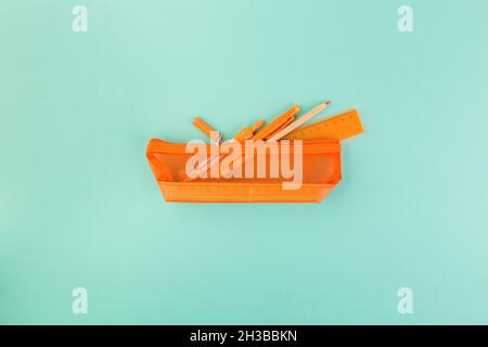 Different orange school supplies in case. Back to school concept. Flat lay, top view, copy space Stock Photo