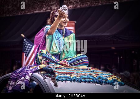 2019 08 31 Tahlequah USA Seminole Indian Princess sits cross legged on colorful robes on top of car in Cherokee Holiday paragde down main street. Stock Photo