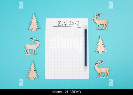 Goals 2022, empty paper, christmas time, making plans for the new year, copy space, blue colored background Stock Photo