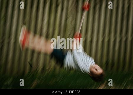 Blissful boy on backyard swing Stock Photo