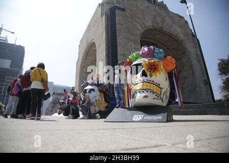A  child poses  in front of a monumental skull during the Frida Kahlo Skulls exhibition at Revolution Monument as part of Day of the Dead Mexican celebrations. On October 26, 2021 in Mexico City, Mexico.(Photo by Ismael Rosas/ Eyepix Group) Stock Photo