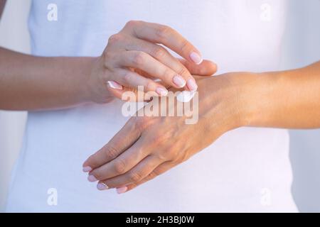 Woman applying moisturizer on her dry hands. Hand cream. Skin protection. Hand care or skin care concept Stock Photo