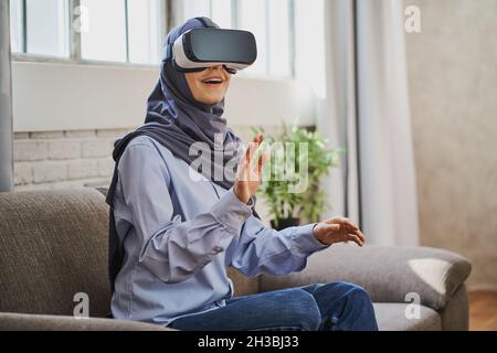 Astonished Muslim woman using a VR headset for the first time Stock Photo