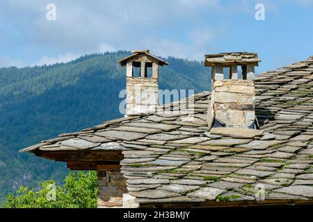 Roof with old chimneys of a house in the Revival village of Leshten, Bulgaria. Old Rhodope village. Stock Photo