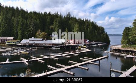 Small village Telegraph Cove, Vancouver Island in autumn (off-season) with buildings on stilts and empty pier reflected in the calm water. Stock Photo
