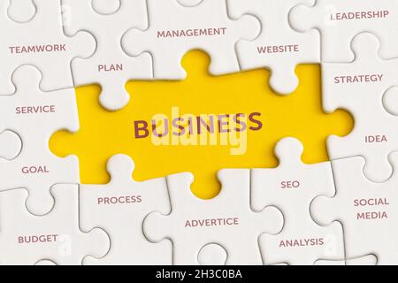 White details of puzzle with the text 'Business' on yellow background. Stock Photo