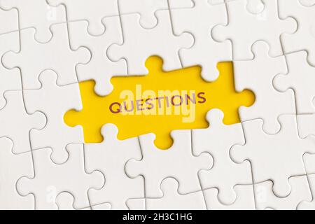 White details of puzzle with the text 'Questions' on yellow background. Stock Photo