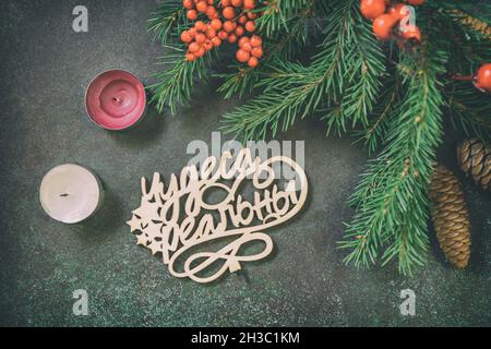 Christmas flat lay with fir tree branch, candles and Christmas decorations on a dark green stone background. Stock Photo