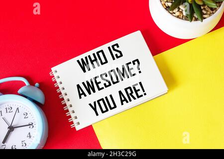 Who is cool You Positive affirmation and personal development concept. Written on a notepad and a red and yellow background. Near an alarm clock and a Stock Photo