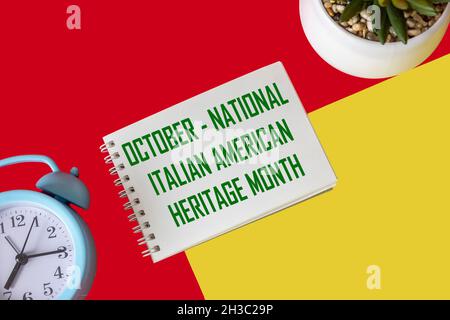 October - National Italian American Heritage Month, text on notepad and red and yellow background. Cultural reminder. Stock Photo
