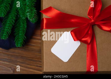 A large gift in a craft box with a label with free space for an inscription. New Year mockup with place for text. Stock Photo