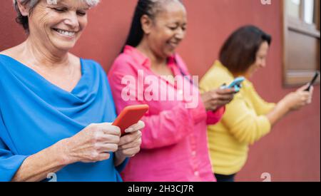 Senior happy people using mobile phones outdoor - Elderly lifestyle technology concept Stock Photo