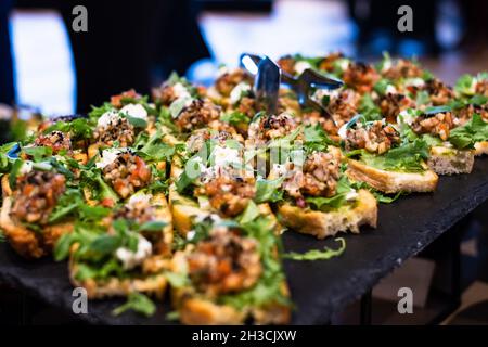 Bruschetta with tomato salsa and fresh basil. Italian Antipasti and snacks served at catering event or party. Stock Photo