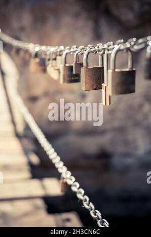 Close up shot of many padlocks on a chain, metaphor for a love relationship. Stock Photo