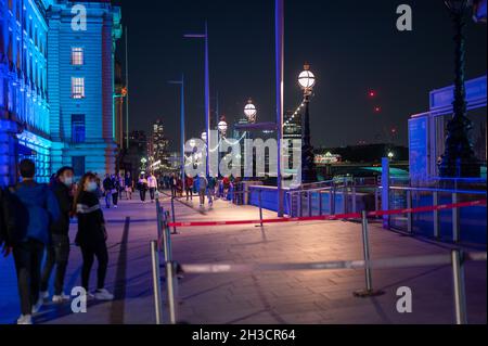 LONDON - SEPTEMBER 14, 2021: Colourfully lit night scene on The Queen's Walk, Southbank between The London Eye and County Hall Stock Photo