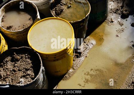 Contained motor oil and diesel fuel with contaminated soil in buckets Stock Photo