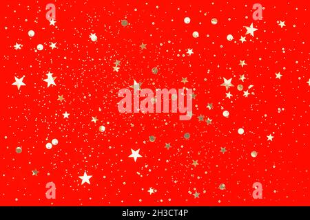 Golden confetti on red background. Christmas concept. Flat lay, top view Stock Photo