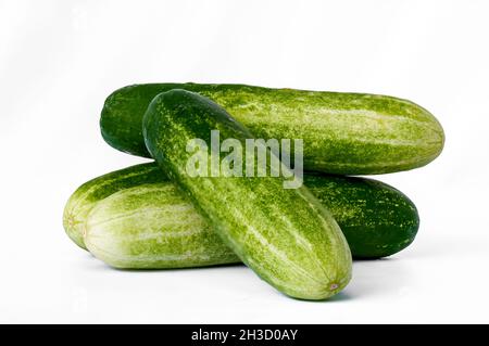 Four cucumbers for greens, in a stack composition, isolated on a white background, copy space Stock Photo