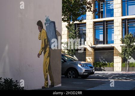 The Garbage Man - Trompe-l'oeil mural of man in hazmat suit collecting a trash (and alien), by Greg Brown, at 136 Hamilton Ave, Palo Alto, California Stock Photo