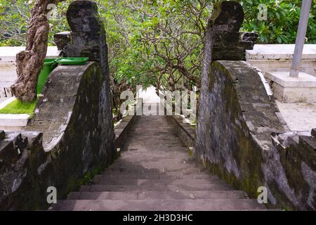 View of trees along ancient stone stairway at Uluwatu temple in Bali, Indonesia. No people.