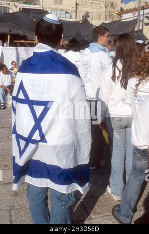 ISRAEL . JERUSALEM . YOUNG MAN CARRYING THE ISRAELI FLAG Stock Photo
