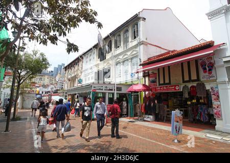Pagoda street with old shophouses and several people walking in Singapore's Chinatown district. Stock Photo