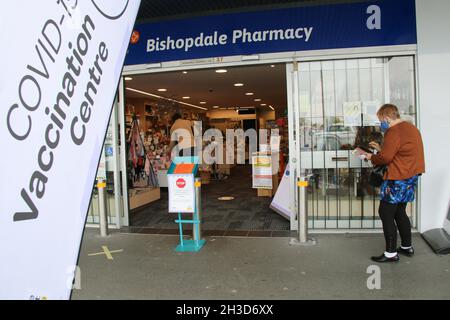 Christchurch, New Zealand. 28th Oct, 2021. A woman scans a QR Code with her smartphone before entering the Unichem Bishopdale Pharmacy COVID-19 Vaccination Clinic in Christchurch. Bishopdale Mall has been named as an exposure site in Christchurch. Nine people from three families are isolating or in a MIQ (managed isolation quarantine). Credit: SOPA Images Limited/Alamy Live News Stock Photo