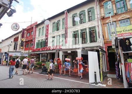 Boutiques, restaurants and the Chinatown Heritage Centre with several tourists in Pagoda Street in Singapore's Chinatown district. Stock Photo