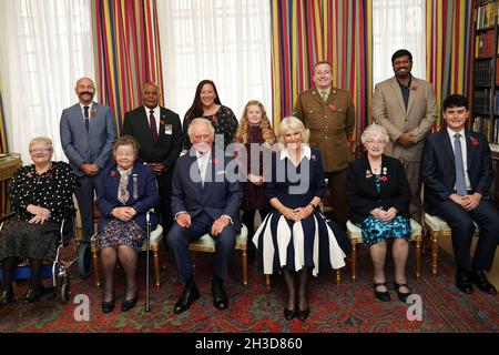 The Prince of Wales (front centre) and Duchess of Cornwall (third right front), with ten Royal British Legion (RBL) Poppy Appeal collectors: (front row L-R) Lesleyanne Gardner, Jill Gladwell, Vera Parnaby, Billy Wilde, and (back row L-R) David Kelsey, Andy Owens, Anne-Marie Cobley, Maisie Mead, Lance Corporal Ashley Martin and Mirza Shahzad at Clarence House, London, during the official launch of the centenary poppy appeal. Picture date: Tuesday October 26, 2021. Stock Photo