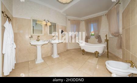 Modern bathroom interior combined with toilet. Shower room and toilet are covered with tiles and a washbasin with a mirror in the center. Stock Photo