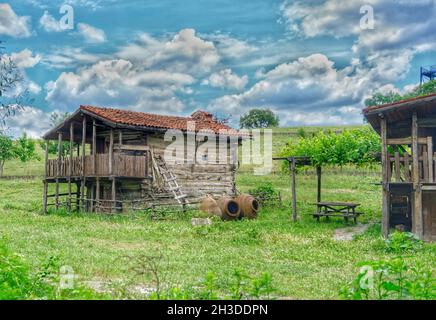 Old abandoned and brownfield village home with green grass and it is established on stone ground in nature with huge clouds background with overcast Stock Photo