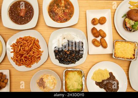 Set of Mediterranean food dishes with pasta with chorizo, white bean stew, meat lasagna, beef meatloaf, Russian salad, jamon croquettes