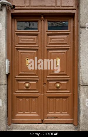 Old wooden entrance door to a stone building painted in brown color Stock Photo