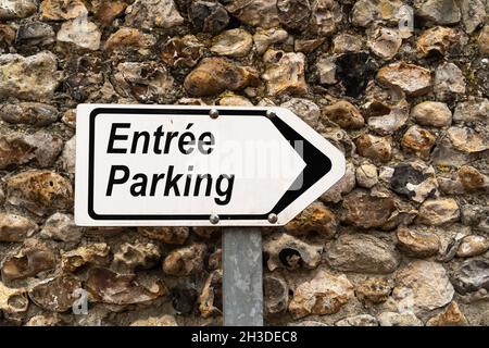 Arrow with a sign in French pointing in the direction of the parking entrance Stock Photo