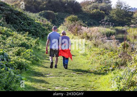 A couple walking along a rural riverside footpath Stock Photo